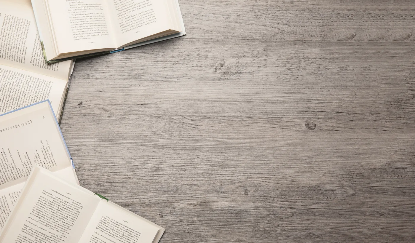 Livros abertos sobre uma mesa de madeira