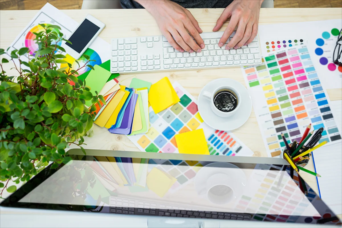 Mesa de produção gráfica com escala de cores e materiais